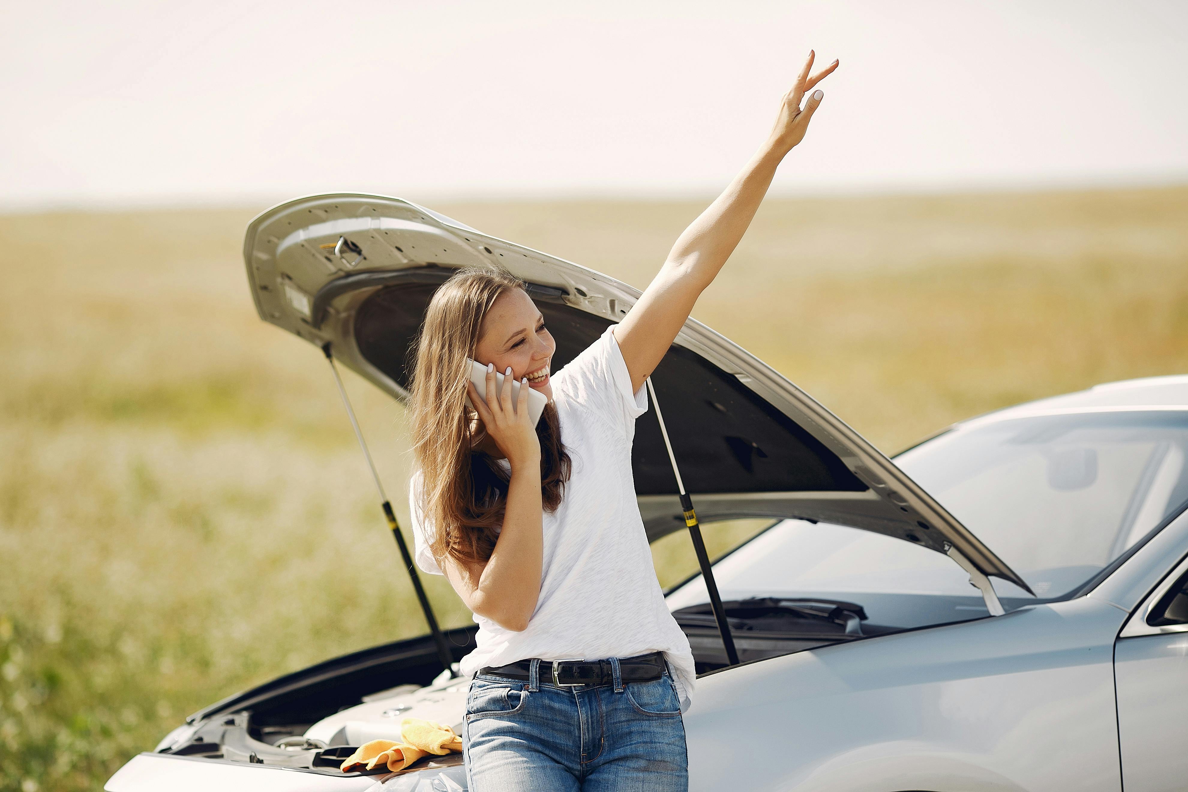 Woman with broken down car hailing breakdown cover van 